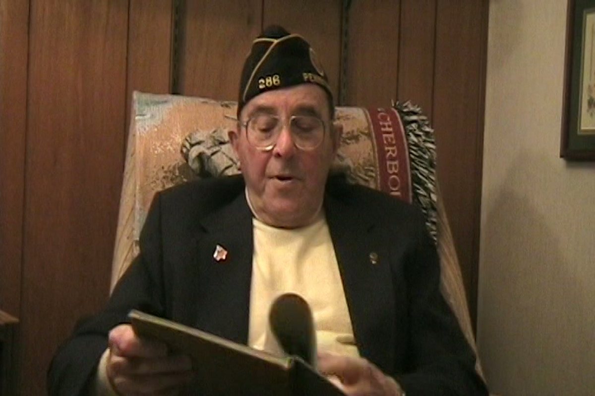 This exact moment on tape: Allen holds up his own copy of “The Reaper's Harvest” as he says, “This is a book put out by our third bomb group of some of the actions in our time over there.”