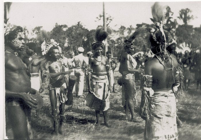 New Guinea villagers gathered in traditional dress at a ceremonial event.