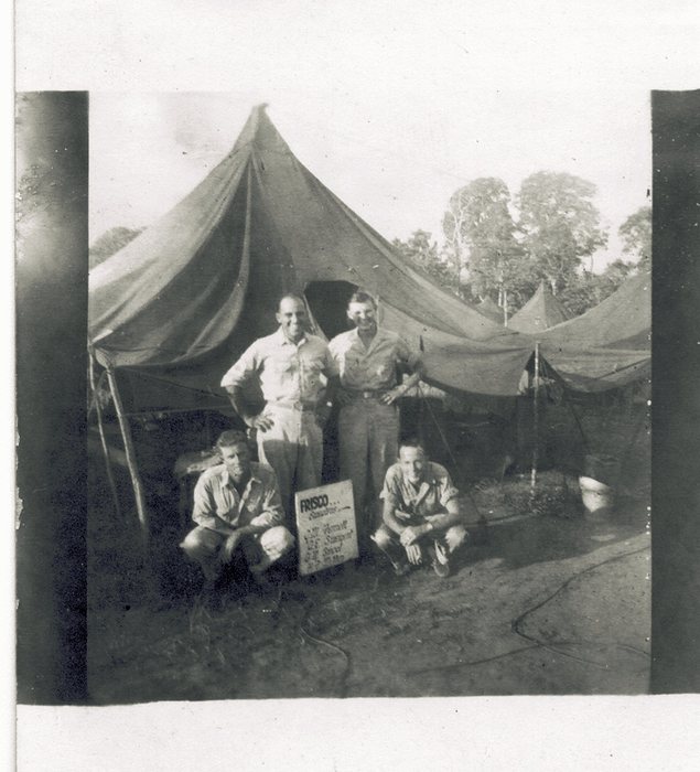 Four servicemen pose beside the same 