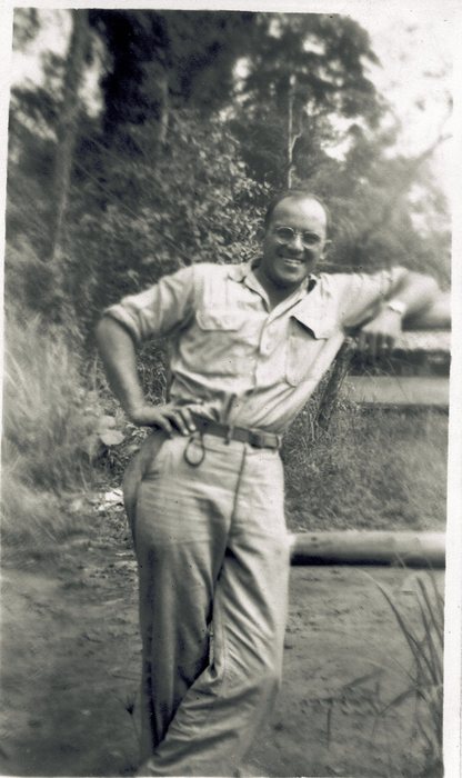 Allen, grinning, leans against a fence post.