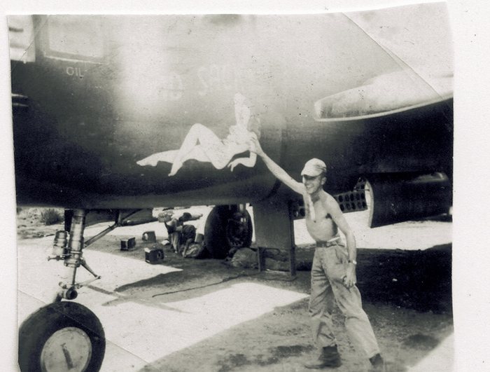 “Sad Sack” nose art, a bomb-loading cart beneath the fuselage.