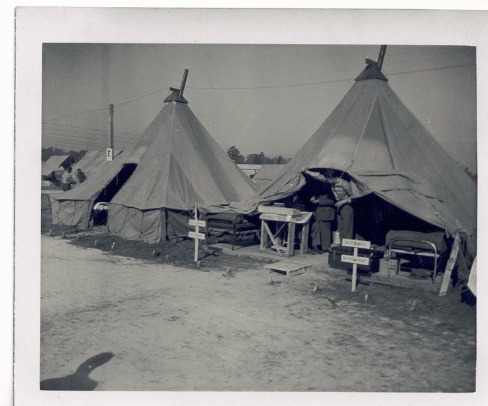 A company street of tents, one marked with the letter “F” for Battery F.