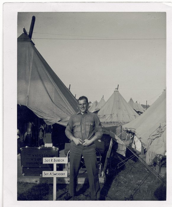 A hand-lettered camp sign reads “SGT. R. BUBECK” and “SGT. A. SWEIGERT” — Allen's own name, in camp.