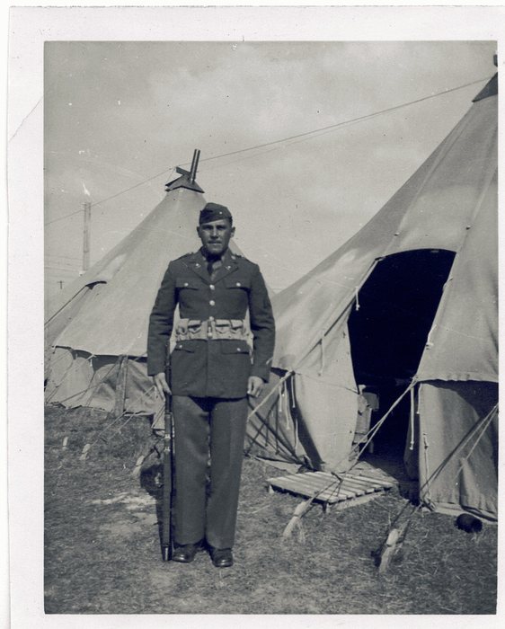 Allen stands at attention in full dress uniform, rifle at his side.