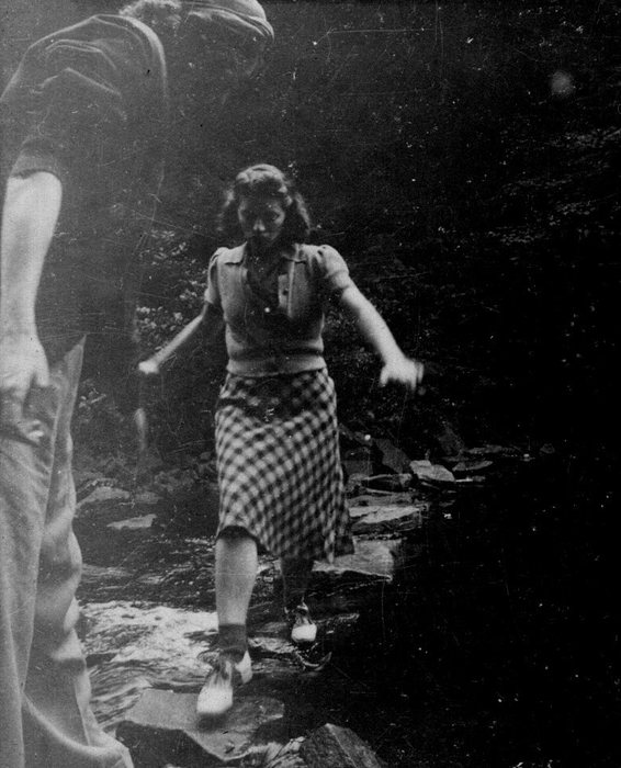 Allen and Catherine dating, before the war — she crosses a woodland stream on stepping stones.