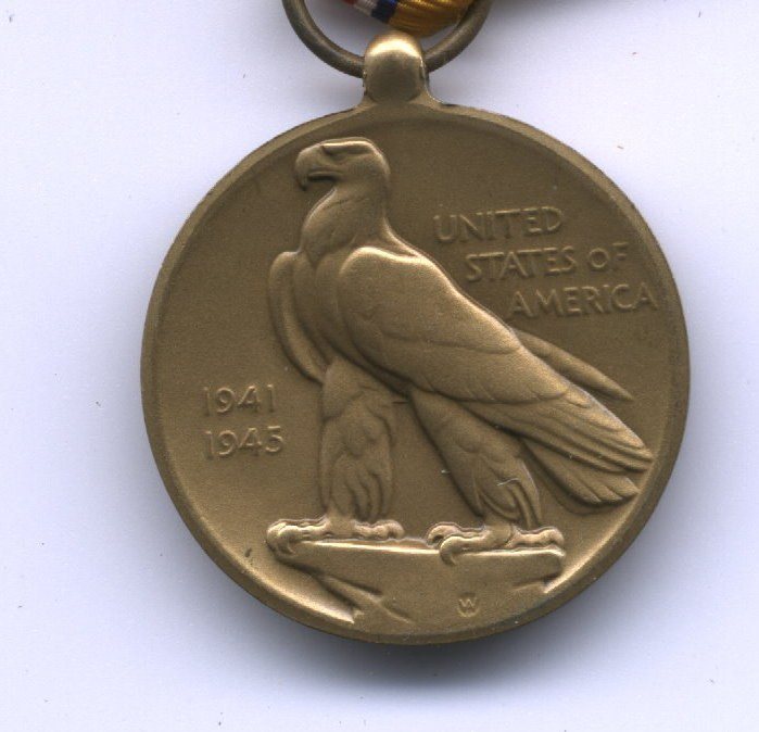 The reverse of a bronze campaign medal: a bald eagle in high relief facing left, "UNITED STATES OF AMERICA" lettered in three lines to the right of it and the dates "1941" and "1945" to the left. A small "W" is struck into the field below the eagle's feet, and a striped ribbon shows through the suspension ring at the top.
