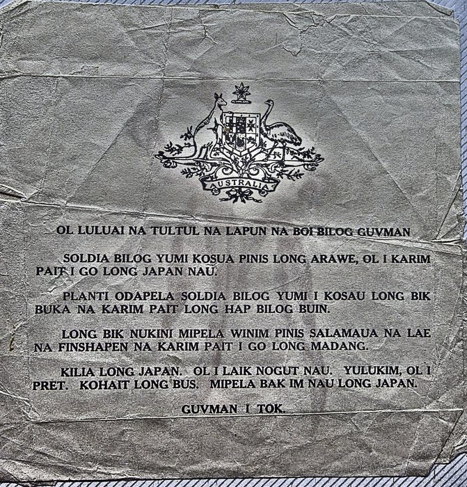 The printed reverse of the same Tok Pisin leaflet, a single creased and much-folded sheet headed by the Australian coat of arms on a scroll lettered "AUSTRALIA". The text opens "OL LULUAI NA TULTUL NA LAPUN NA BOI BILOG GUVMAN", tells of the fighting at Arawe and past Salamaua, Lae, Finschhafen and Madang, and closes "GUVMAN I TOK."