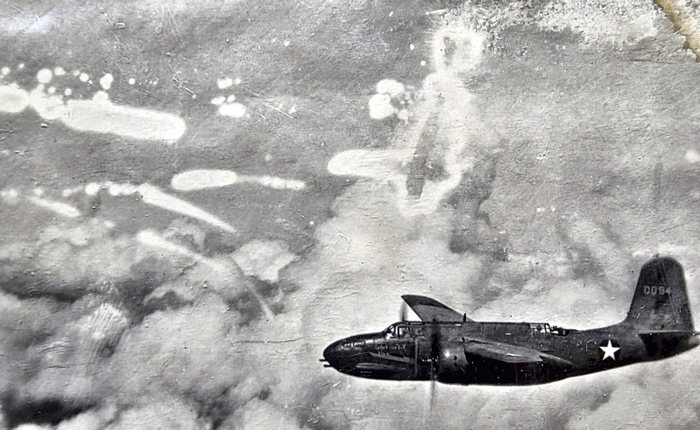 A Douglas A-20 Havoc seen in profile from slightly above, crossing the frame nose-left: a solid, unglazed nose -- a field strafer conversion -- a single tall fin carrying the number <b>0094</b>, and a plain white star-in-circle with no bars on the rear fuselage. The air ahead of and above it is streaked with pale puffs and trails of smoke.